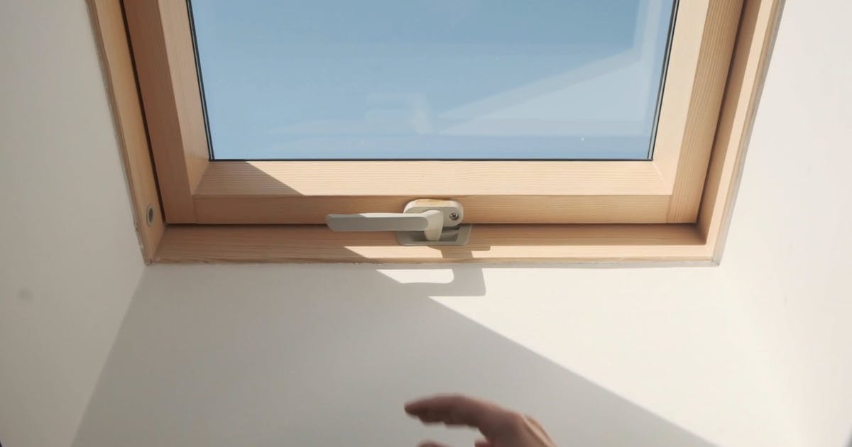 Roof window with a wooden frame seen from the room below