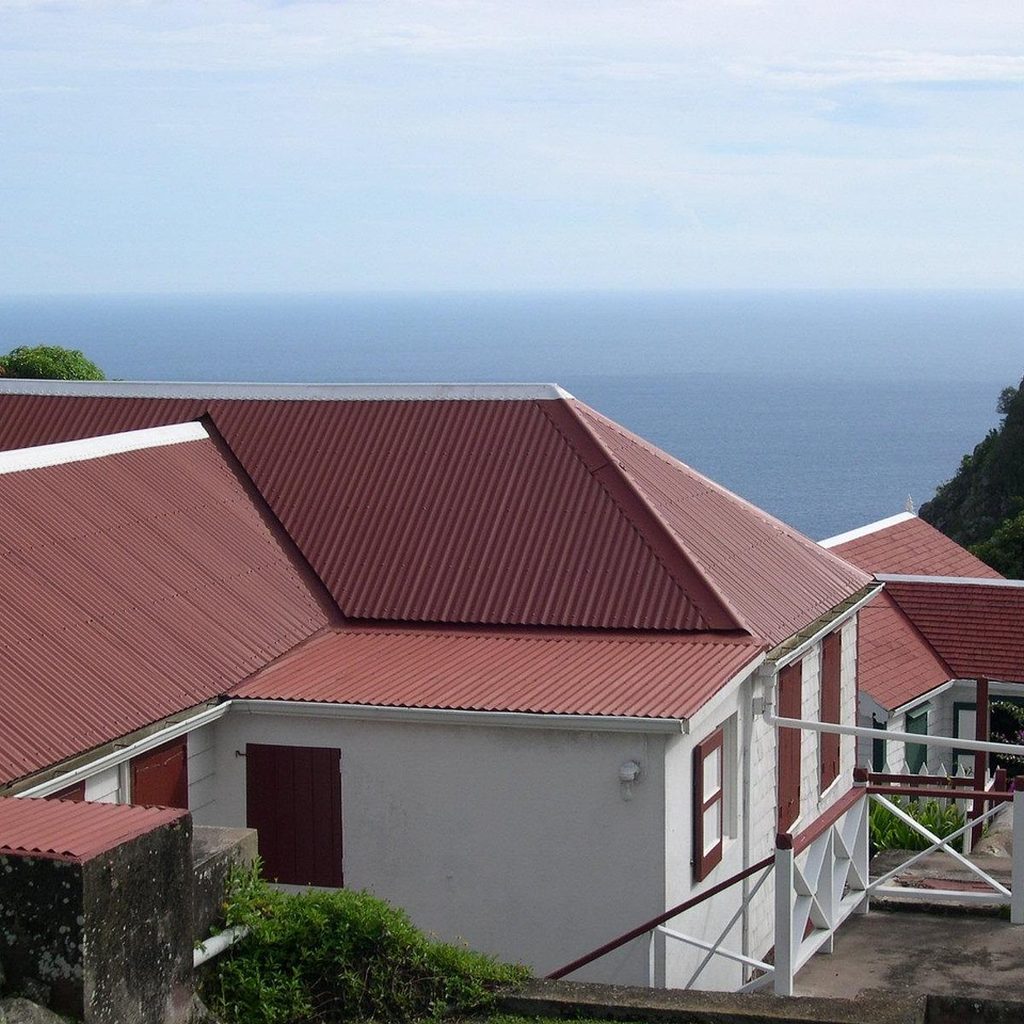 White house with a red metal roof above the sea